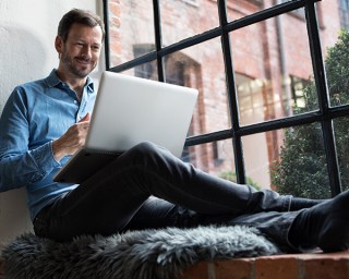 Man holding a laptop and smiling